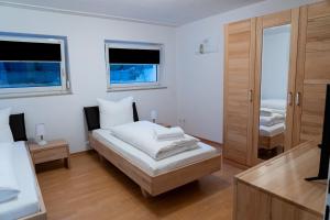 a white room with a bed and two windows at Studio 17 FeWo Schwaigern in Schwaigern