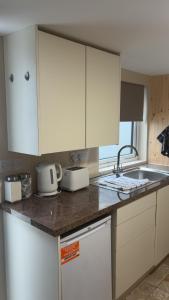 a kitchen with white cabinets and a sink at O'Briens Luxury Studio City Centre in Galway
