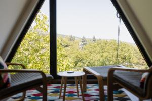 a room with a table and chairs and a large window at A Hely Ahol in Nagymaros