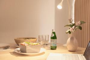 a table with a bowl of food and a laptop computer at 2R3B, 공항버스 도보4분,2호선line 강남20분 홍대18분 명동 성수, 무료주차 ,짐보관서비스 in Seoul +14 photos