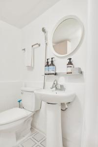 a white bathroom with a sink and a mirror at 2R3B, 공항버스 도보4분,2호선line 강남20분 홍대18분 명동 성수, 무료주차 ,짐보관서비스 in Seoul