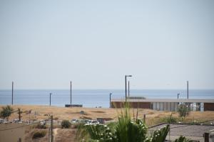 a beach with a building and the ocean in the background at Apartment House in Costa da Caparica