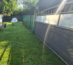 a fence in a yard with a tent at Camping: bring your tent or van in Feldkirchen bei Graz