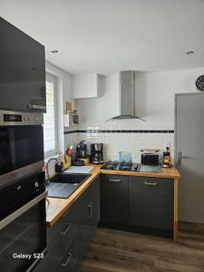 una cocina con fregadero y estufa horno superior en Spacious house in La Rochelle near the beaches, en Vautreuil