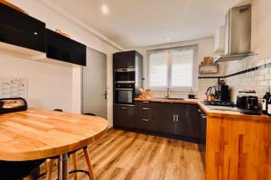 cocina con mesa de madera y suelo de madera en Spacious house in La Rochelle near the beaches, en Vautreuil