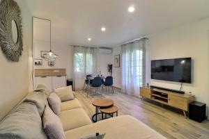a living room with a couch and a flat screen tv at The Maisonnette in the pines in Ventabren +5 photos