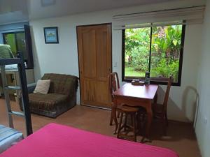 a living room with a table and a chair at Apartment-Pura Vida-wi-fi-6 people, AC- parking-river-garden in Fortuna +110 photos