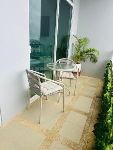 a patio with a glass table and chairs on a balcony at Apartment Karon SeaView 72 sq in Karon Beach