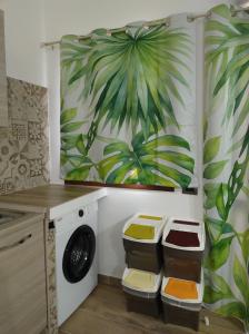 Quartu Sant'ElenaにあるJungle Loftの洗濯機と絵画付きのランドリールーム