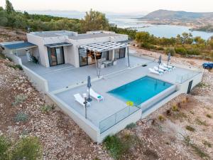 eine Luftaufnahme eines Hauses mit Swimmingpool in der Unterkunft Eleage Villas in Lefkada Town