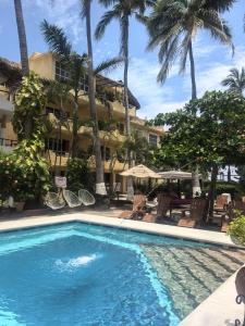 a swimming pool in front of a hotel with palm trees at BEACH HOTEL INES en Zicatela in Brisas de Zicatela