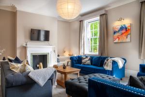 ein Wohnzimmer mit blauen Möbeln und einem Kamin in der Unterkunft Huge 6 Bedroom House in Central Derby in Derby