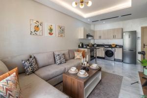 a living room with a couch and a kitchen at Cozy studio with great pool views in Aïn Harrouda