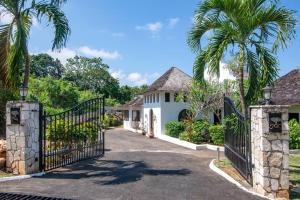 a gate to a house with palm trees at Hospitality Expert HALF HILL Pool Beach in Montego Bay