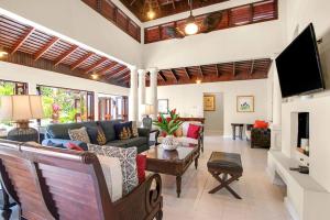 a living room with a couch and a tv at Hospitality Expert HALF HILL Pool Beach in Montego Bay