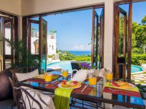 a table with plates of food on top of a balcony at Hospitality Expert HALF HILL Pool Beach in Montego Bay