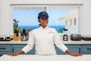 a woman standing in a kitchen with her arms crossed at Hospitality Expert HALF HILL Pool Beach in Montego Bay +71 photos