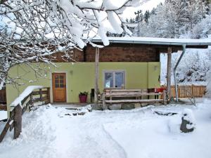 a log cabin in the snow with a porch at Apartment Benjamin by Interhome in Hollersbach im Pinzgau