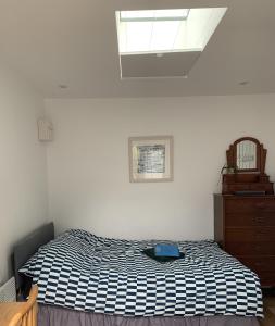 a bedroom with a black and white bed and a dresser at Garden room with parking in Lewes