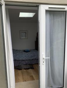 a sliding glass door with a bed in a room at Garden room with parking in Lewes