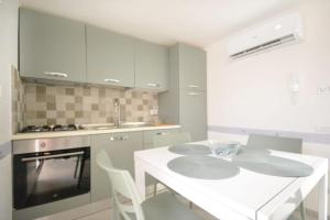 a white kitchen with a white island in a room at Casa Carmela in San Vito dei Normanni