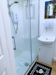 a small bathroom with a shower and a sink at Garden room with parking in Lewes