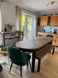 a kitchen with a wooden table and green chairs at Pebbles & Prosecco in Brighton & Hove