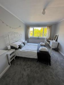 a bedroom with a large bed and a window at Pebbles & Prosecco in Brighton & Hove