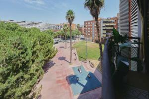 a balcony with a view of a pool and palm trees at 3 bedroom Huge apartament near the beach in Sant Adria de Besos