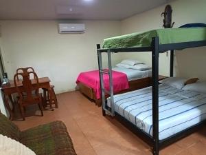 a bedroom with two bunk beds and a desk at Apartment-Pura Vida-Wi-Fi-TV-WC-AC-Parqueo in Fortuna