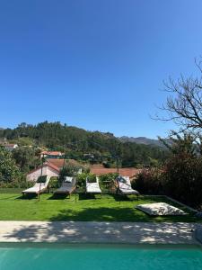 a group of swings in a park with green grass at Casa Ermida in Pincães