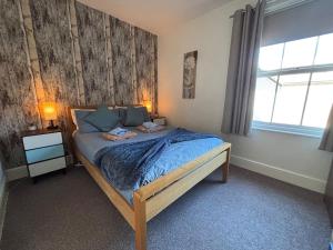 a bedroom with a bed with a wooden frame and a window at 11B Beachside in Eastbourne