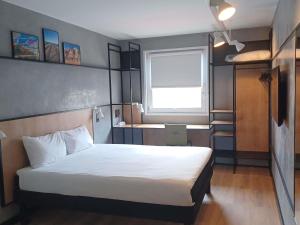 une chambre avec un lit blanc et une fenêtre dans l'établissement Ibis Hotel Alicante, à Alicante