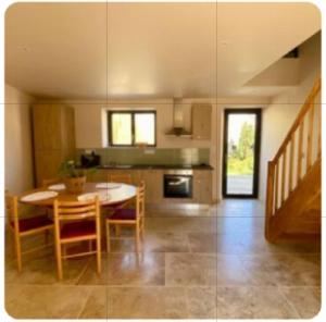 a kitchen and dining room with a table and chairs at Chambre du saule in Fouronnes