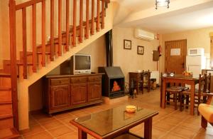 a living room with a staircase and a fireplace at Apartamentos Valle del Guadalquivir in Arroyo Frio