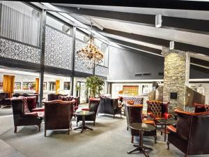 a restaurant with chairs and tables and a chandelier at Gautefall Ski inn-Ski out in Drangedal