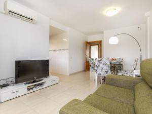 a living room with a couch and a tv and a table at Apartment República Dominicana by Interhome in Miami Platja
