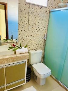 a bathroom with a toilet and a sink at Casa Lalivi Trancoso in Porto Seguro +7 photos