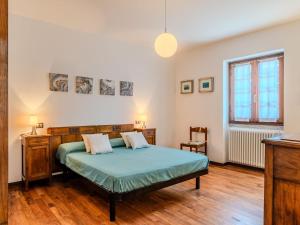 a bedroom with a bed in a room with wooden floors at Apartment Beppe by Interhome in Peglio