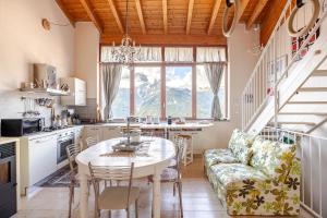 a kitchen and dining room with a table and a couch at Casa magnifica Valle Camonica in Cimbergo