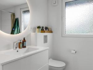 a white bathroom with a sink and a mirror at Holiday Home Hubertina - 75m from the sea by Interhome in Hejlsminde