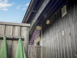 a door to a metal building with a fence at Holiday Home Hubertina - 75m from the sea by Interhome in Hejlsminde