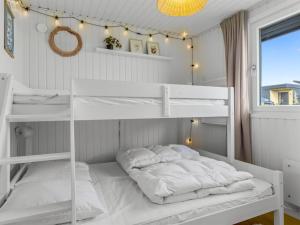 a bedroom with two bunk beds and a window at Holiday Home Hubertina - 75m from the sea by Interhome in Hejlsminde +17 photos