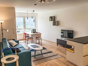 a living room with a couch and a table at Apartment Top 5 Alpe maritima Seeblick-Bergkulisse by Interhome in Annenheim