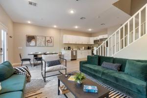 a living room with a green couch and a table at 2 Large Vacation Suites Pool - Patio - Games in Surprise