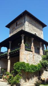 un edificio alto de ladrillo con balcón. en La Torre Medioevale, en Marne di Filago