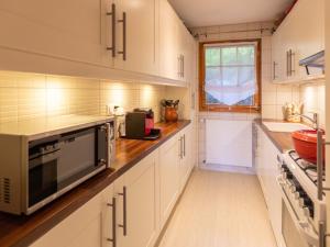 Una cocina con gabinetes blancos y un microondas. en Apartment Les Hespérides 2 by Interhome, en Villars-sur-Ollon 32 fotos más