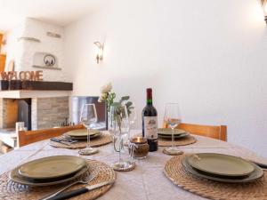 a table with plates and glasses and a bottle of wine at Apartment Vermont 8 by Interhome in Villars-sur-Ollon +30 photos