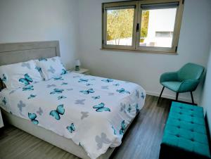 a bedroom with a bed with blue butterflies on it at Quintal do Olival- Um refúgio na Natureza in Lousã +15 photos