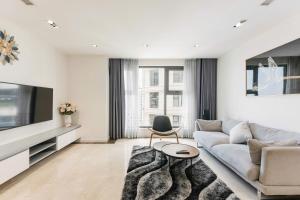 a living room with a couch and a tv at D’Leroi Soleil - Westlake Suite & Apartment in Hanoi